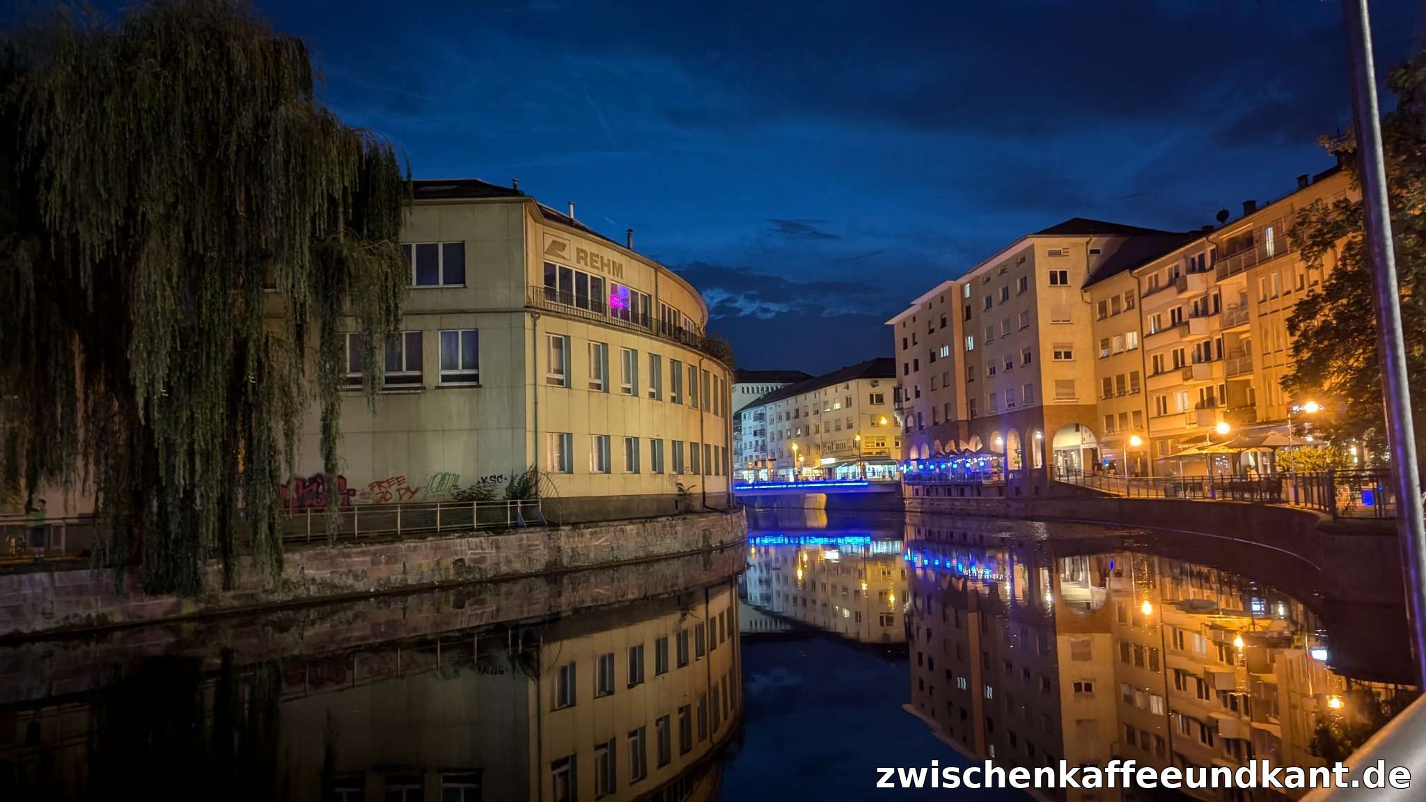 Radfahrer in Pforzheim entlang der Enz bei Nacht, mit beleuchteten Häusern und Spiegelung im Wasser – Beitragsbild zum Verkehrskonflikt.