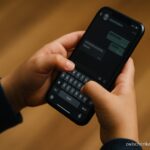 Ein Kind hält ein Smartphone mit geöffneter Chat-App – Symbolbild für Chatkontrolle und Kinderschutz.